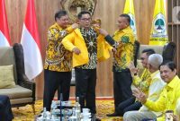 Gubernur Jawa Barat Ridwan Kamil saat memakai jas kuning yang diberikan langsung oleh Ketum Partai Golkar Airlangga Hartarto di DPP Golkar, Jakarta,Rabu (18/1/2023). Ridwan Kamil resmi bergabung dengan Partai Golkar. (Liputan6.com/Angga Yuniar)